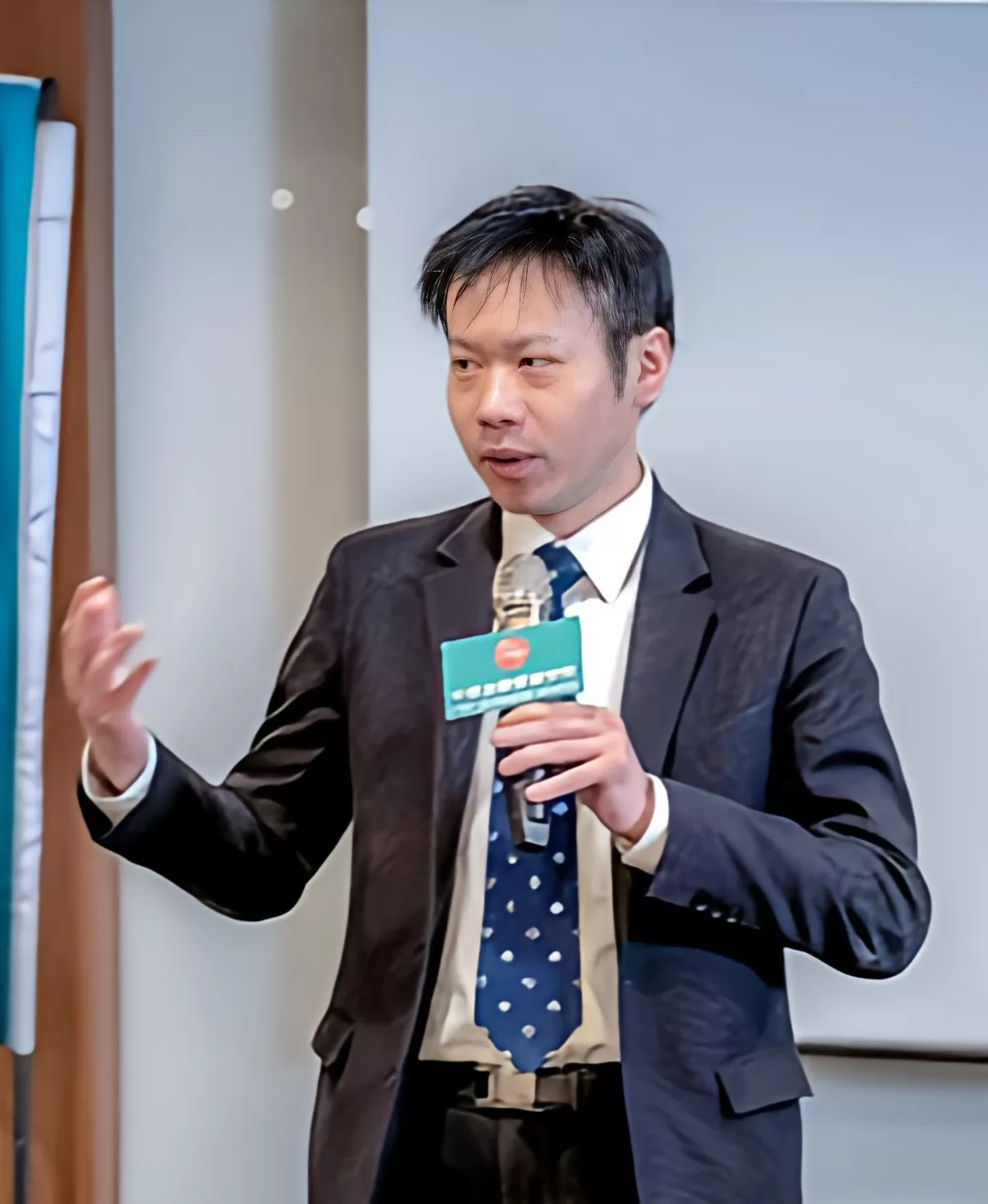 柯宗余 主任於演講現場手持麥克風的照片