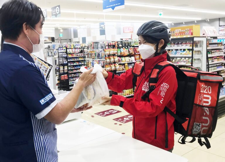 穿著紅色 menu 制服、背著 menu 配送包的配送員在 LAWSON 門市取餐